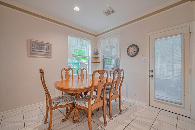 dining space featuring light tile patterned floors, baseboards, and crown molding