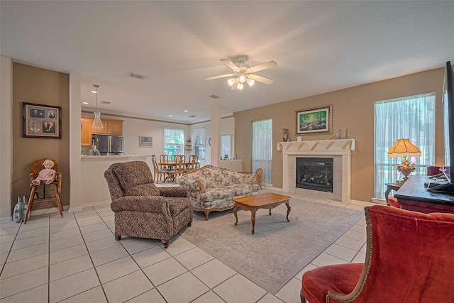 living area with light tile patterned floors, ceiling fan, a tile fireplace, baseboards, and recessed lighting