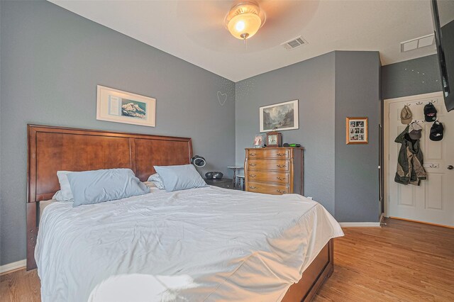 bedroom with light wood-type flooring, baseboards, and ceiling fan