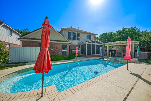 view of swimming pool featuring a sunroom, a fenced backyard, a patio, and a pool with connected hot tub