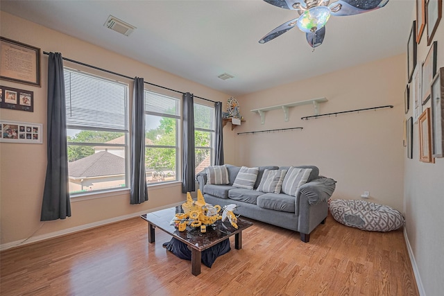 living room featuring light wood finished floors, ceiling fan, and baseboards