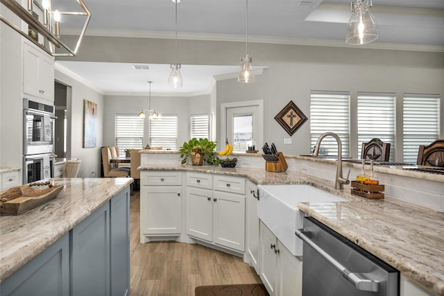 kitchen with crown molding, light wood-style flooring, appliances with stainless steel finishes, and white cabinets