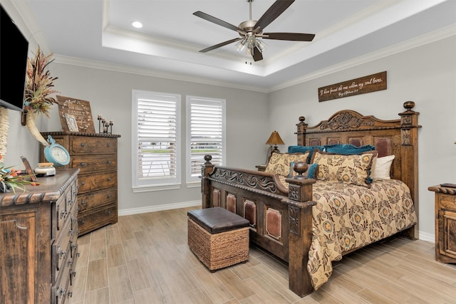 bedroom featuring ornamental molding, a raised ceiling, baseboards, and light wood-style floors