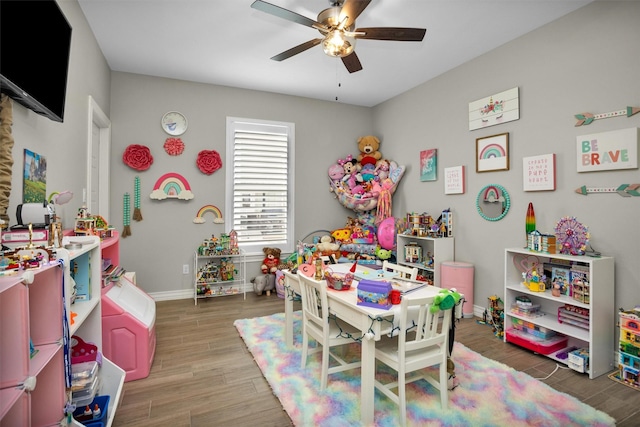 rec room featuring wood finished floors, baseboards, and ceiling fan