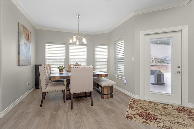dining area featuring baseboards, a notable chandelier, crown molding, and light wood-style floors