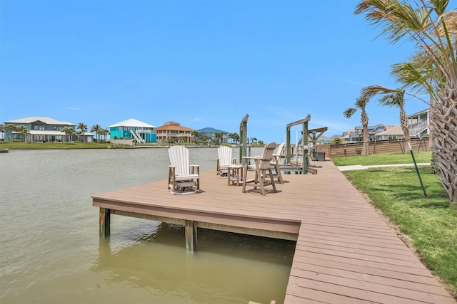 dock area featuring a water view, a residential view, fence, and a lawn