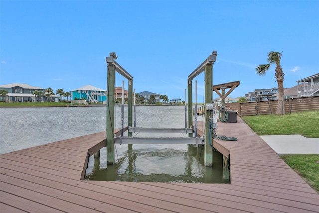 view of dock featuring a water view, boat lift, and a residential view