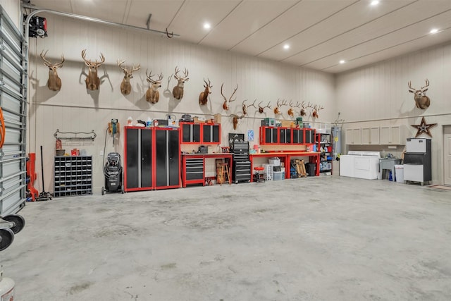 garage with washer / dryer, freestanding refrigerator, a workshop area, and recessed lighting