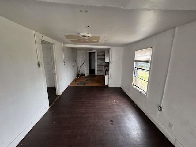 corridor featuring baseboards and wood finished floors