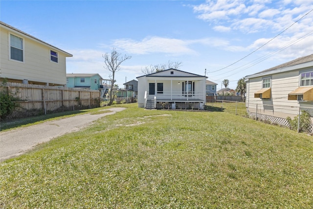 rear view of property with a porch, fence private yard, and a lawn