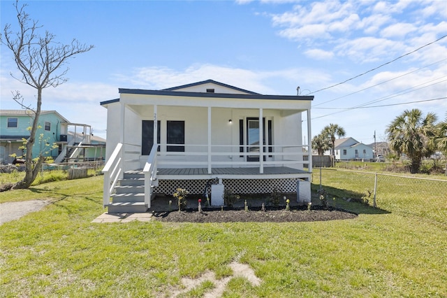 view of front of house with a porch, fence, and a front yard