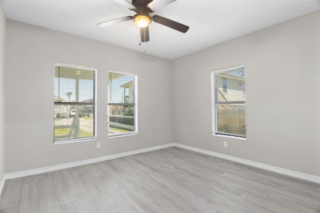 unfurnished room featuring baseboards, ceiling fan, plenty of natural light, and wood finished floors