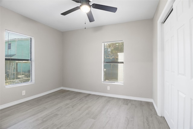 empty room featuring baseboards, a wealth of natural light, and light wood-style flooring