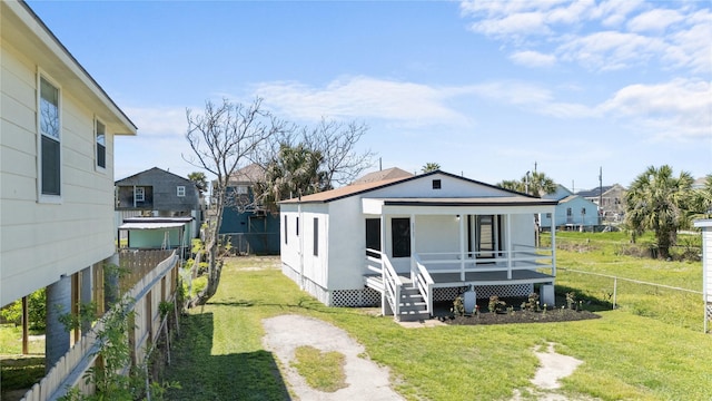 exterior space with a lawn, a porch, stucco siding, and fence private yard