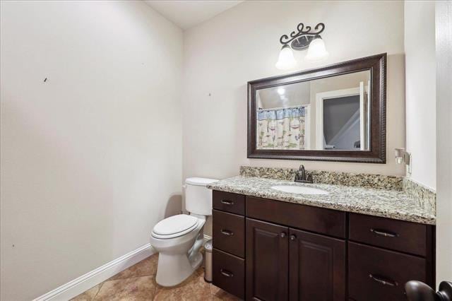 bathroom with vanity, toilet, baseboards, and tile patterned floors