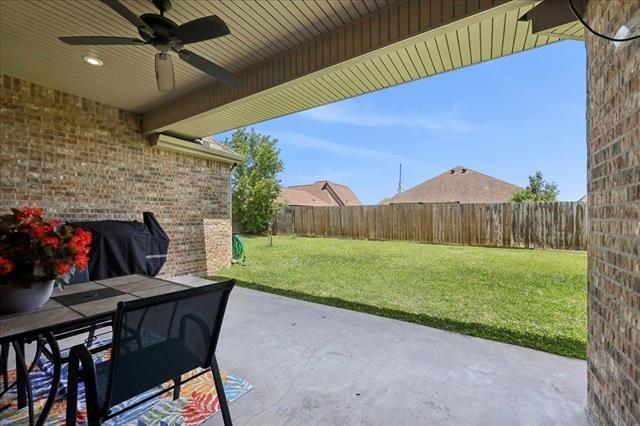 view of patio featuring outdoor dining space, a ceiling fan, and a fenced backyard