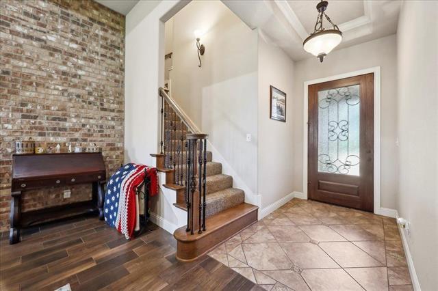 foyer with wood finished floors, baseboards, and stairs