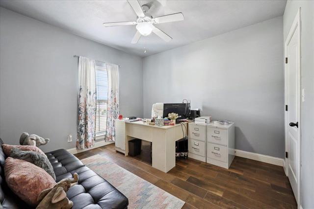 office featuring ceiling fan, baseboards, and dark wood finished floors