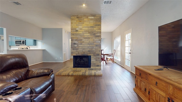 living room with baseboards, a fireplace, visible vents, and dark wood-style floors
