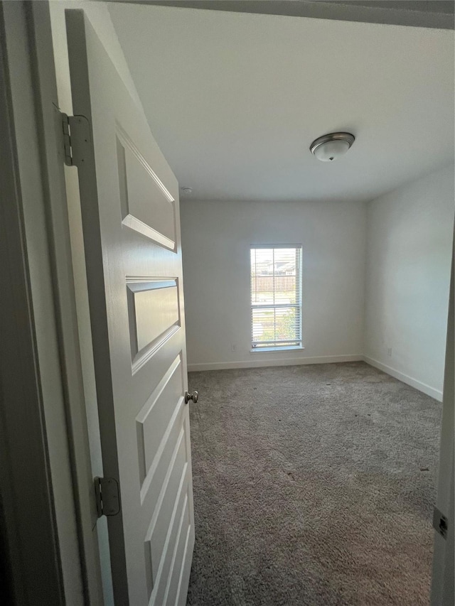 carpeted spare room with baseboards
