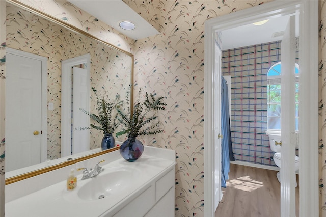 14906 Stonemeade Pl, Cypress, TX 77429 - bathroom featuring vanity, toilet, wallpapered walls, and wood finished floors