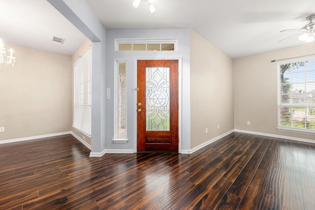 foyer entrance with a ceiling fan, dark wood-style floors, baseboards, and a chandelier