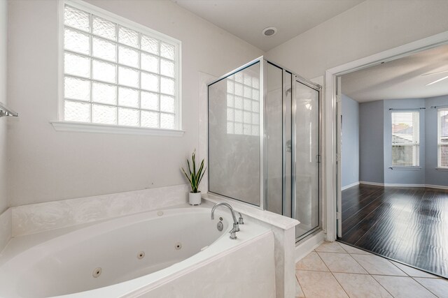full bath featuring a shower stall, a tub with jets, and tile patterned flooring