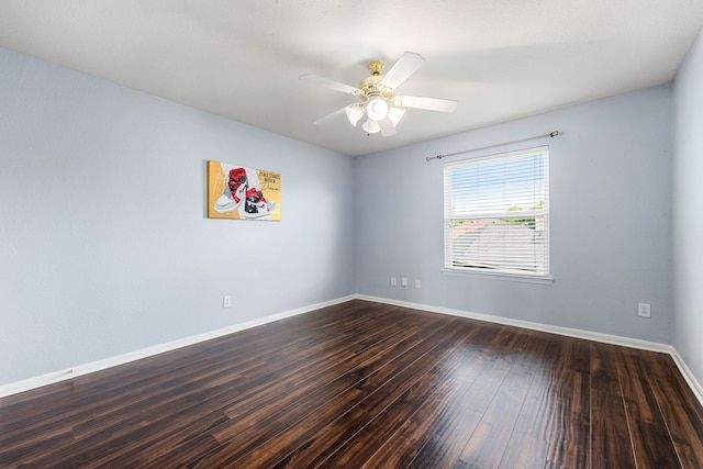 spare room with dark wood-style floors, baseboards, and a ceiling fan