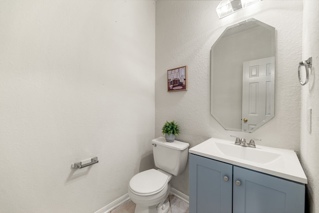 half bathroom with toilet, vanity, and baseboards