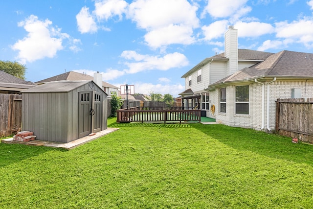view of yard with a storage shed, an outbuilding, and a wooden deck
