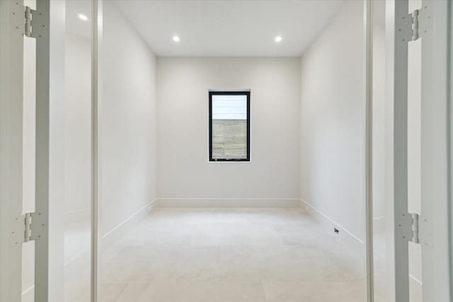 spare room with baseboards and recessed lighting