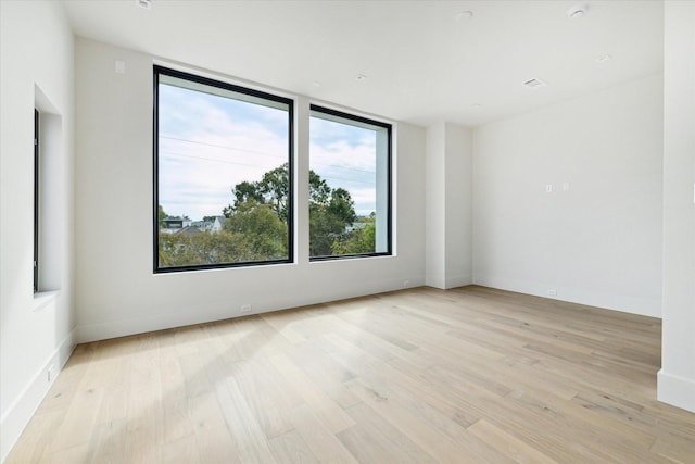 empty room with baseboards and light wood-style flooring