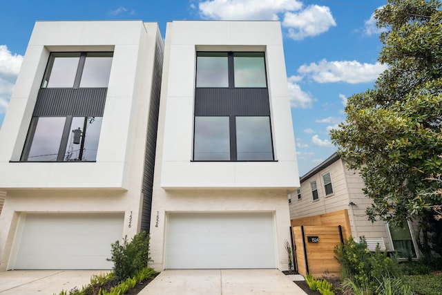 contemporary home featuring concrete driveway, stucco siding, and a garage