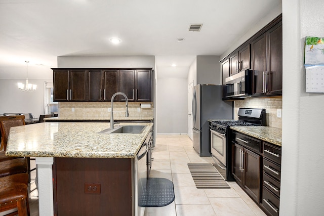 29014 Jacobs River Dr, Katy, TX 77494 - kitchen with stainless steel appliances, a sink, decorative backsplash, and a kitchen breakfast bar