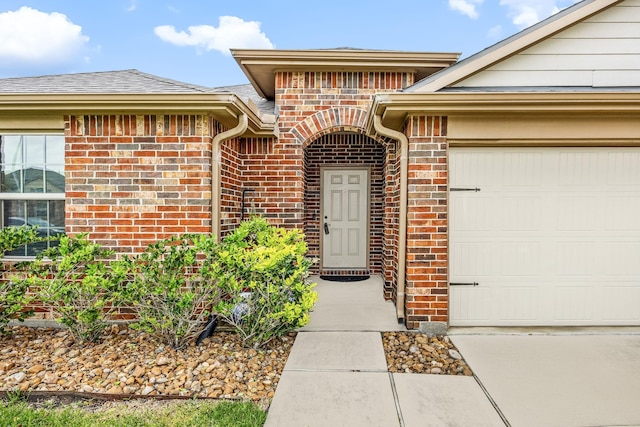 29014 Jacobs River Dr, Katy, TX 77494 - property entrance featuring brick siding, an attached garage, a shingled roof, and concrete driveway