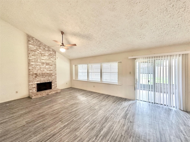 4230 E Terrace Creek Cir, Houston, TX 77014 - unfurnished living room with a textured ceiling, a brick fireplace, wood finished floors, and ceiling fan