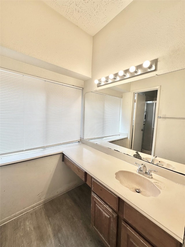 4230 E Terrace Creek Cir, Houston, TX 77014 - bathroom featuring vanity, wood finished floors, a shower stall, and a textured ceiling