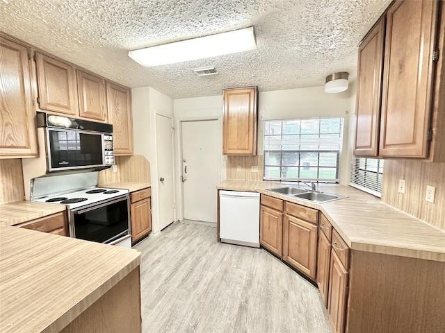 4230 E Terrace Creek Cir, Houston, TX 77014 - kitchen with light wood-style flooring, white appliances, visible vents, a sink, and light countertops