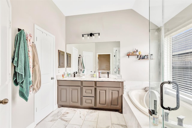 full bathroom with marble finish floor, a sink, double vanity, and a bath