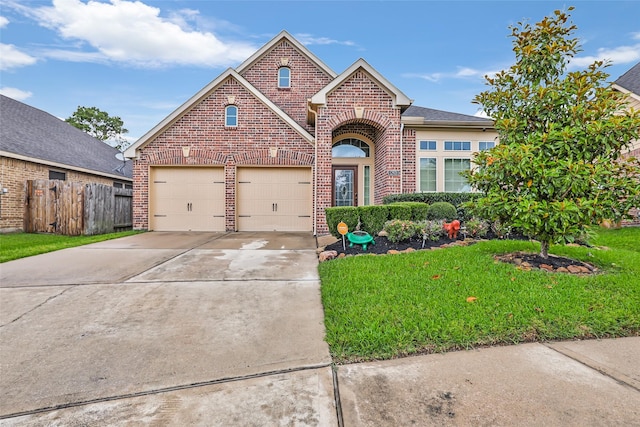 view of front of home with a garage, fence, concrete driveway, a front yard, and brick siding