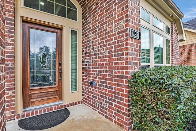 entrance to property featuring brick siding