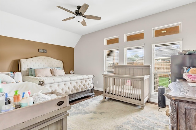 bedroom with wood finished floors, baseboards, a ceiling fan, and lofted ceiling