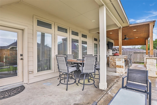 view of patio / terrace featuring ceiling fan, fence, and outdoor dry bar