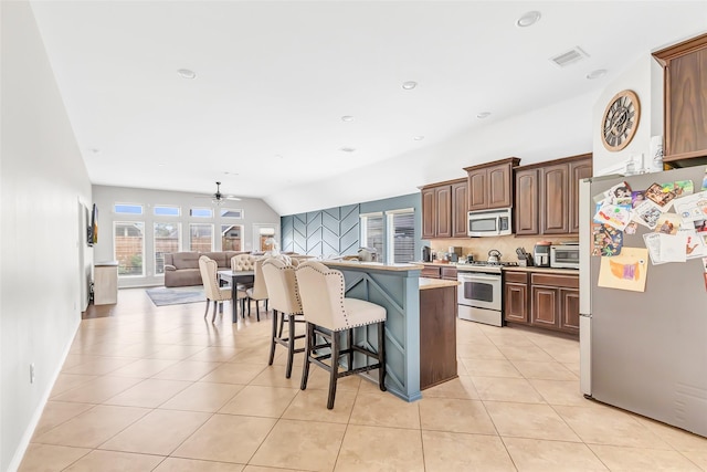 kitchen with stainless steel appliances, tasteful backsplash, visible vents, a kitchen bar, and light tile patterned floors