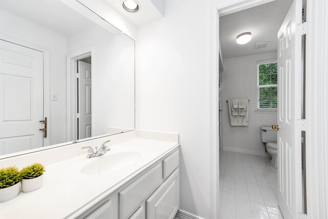 1910 Stormcroft Cir, Katy, TX 77450 - bathroom with baseboards, toilet, vanity, and tile patterned floors