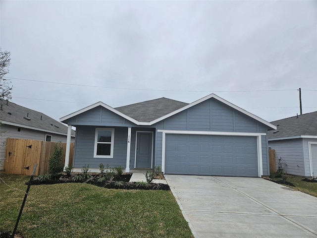 ranch-style home featuring an attached garage, covered porch, fence, a front yard, and driveway