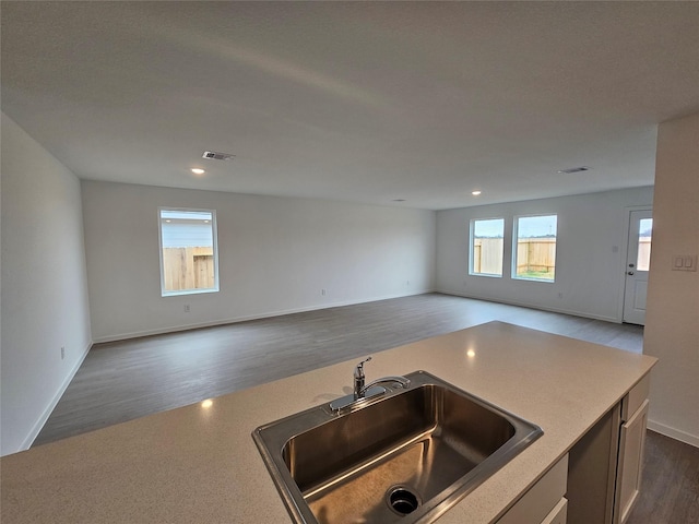 kitchen with dark wood-style flooring, open floor plan, visible vents, and a sink