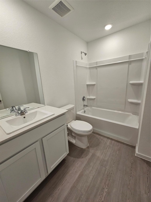 full bathroom featuring toilet, tub / shower combination, visible vents, and wood finished floors