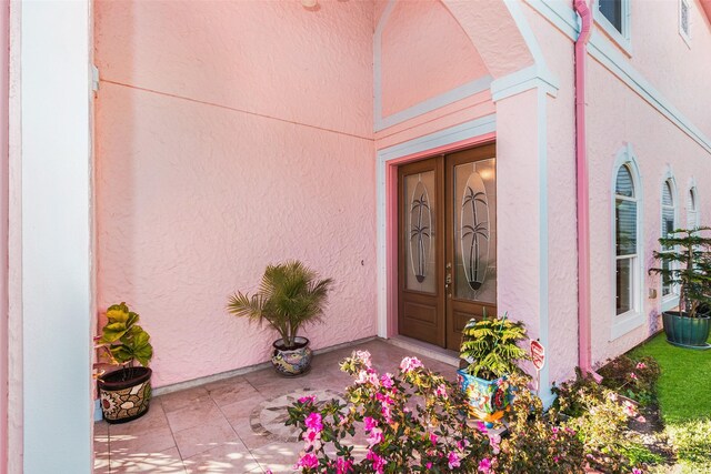 view of exterior entry with stucco siding and french doors