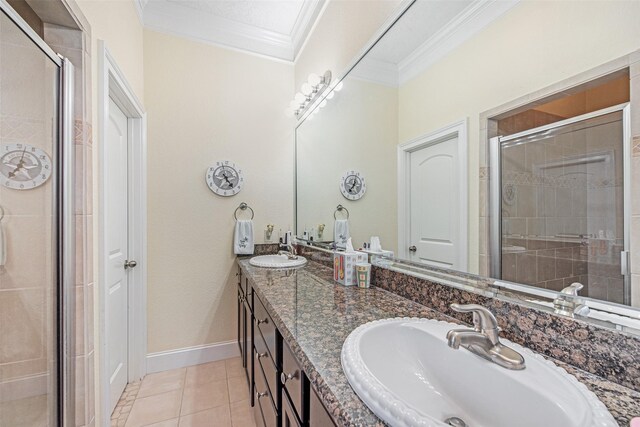 full bath featuring a shower stall, tile patterned flooring, crown molding, and a sink